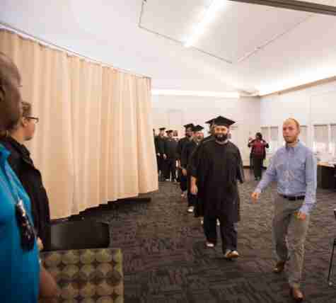 Students wore graduation gowns over their usual blue jumpsuits and slides at graduation.